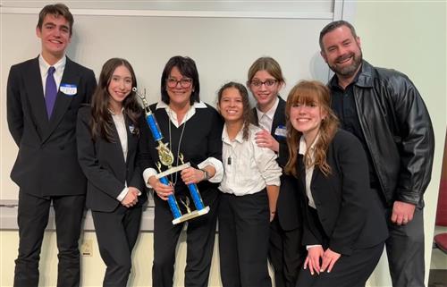 Ethics bowl team poses with their trophy